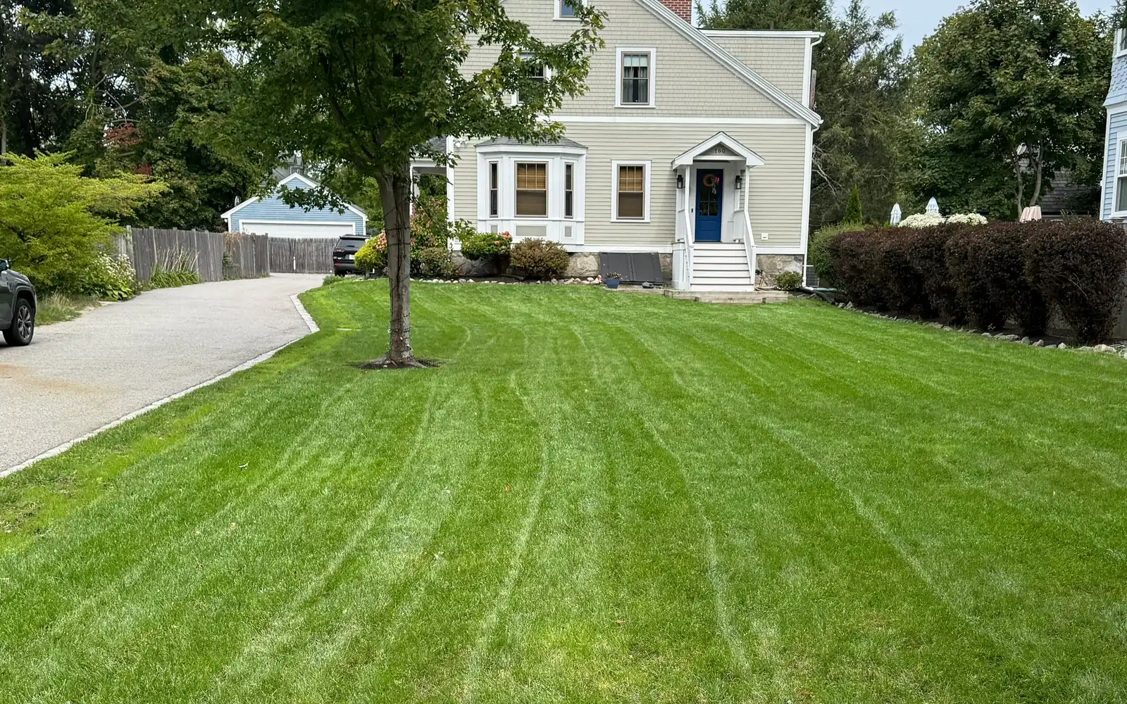 A freshly cut lawn with edged beds in front of a MetroWest home